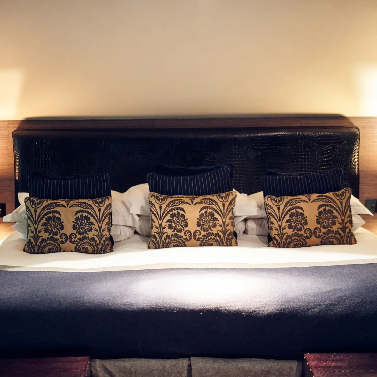 A king sized bed adorned with decorated pillows.