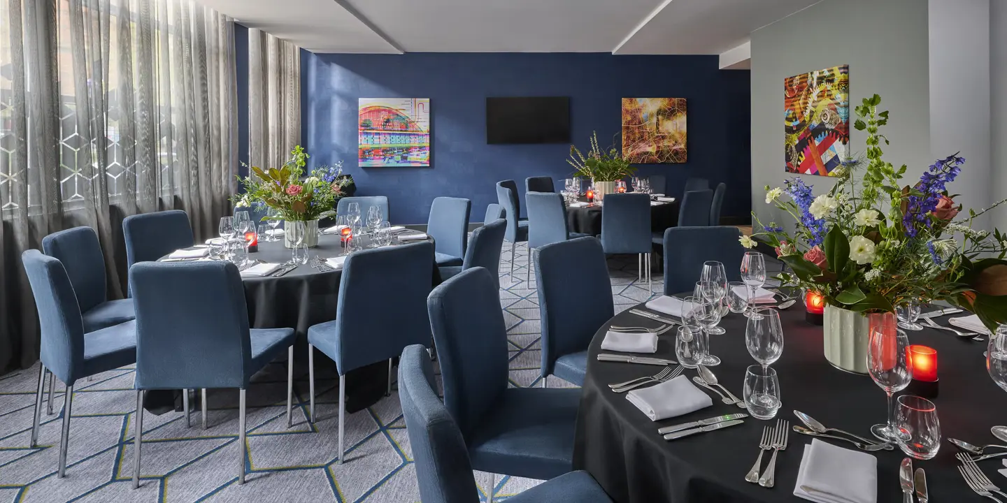 A beautifully arranged table for a formal dinner adorned with elegant candles and exquisite flowers.