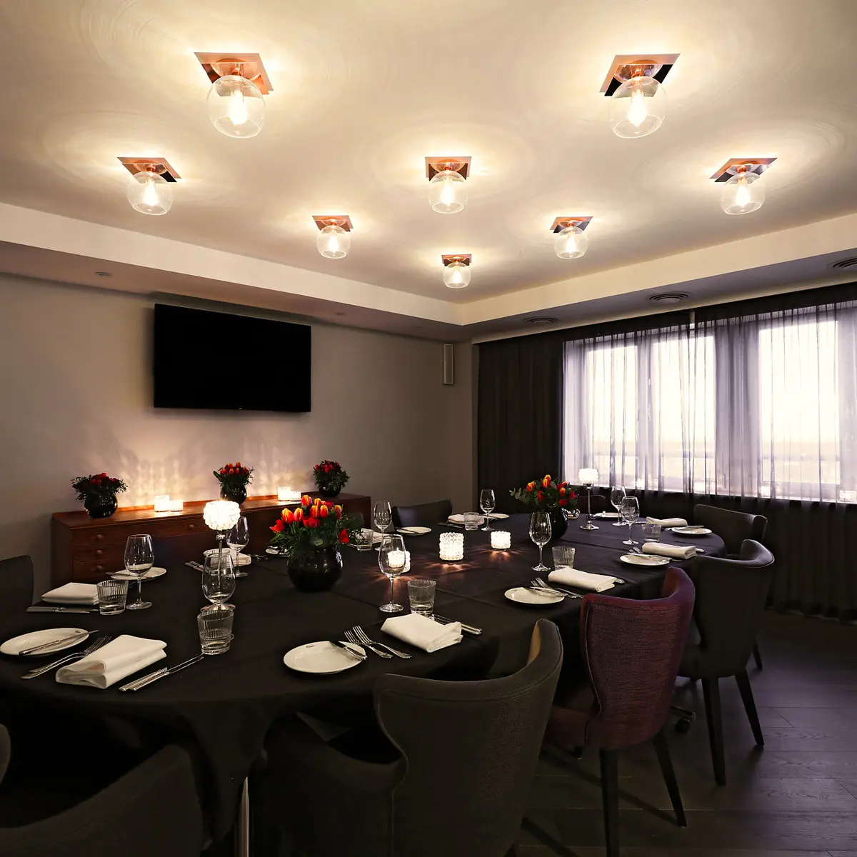 Dining room featuring a table and chairs with round glass ceiling lighting fixtures and a feature window