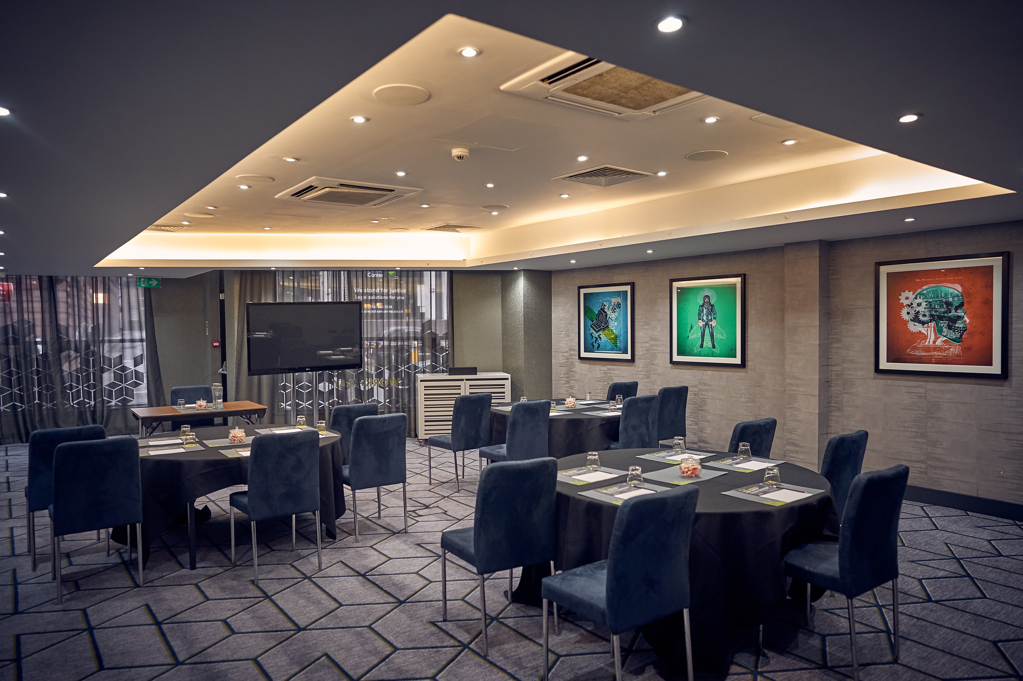 A spacious room adorned with tables, chairs, and wall art.