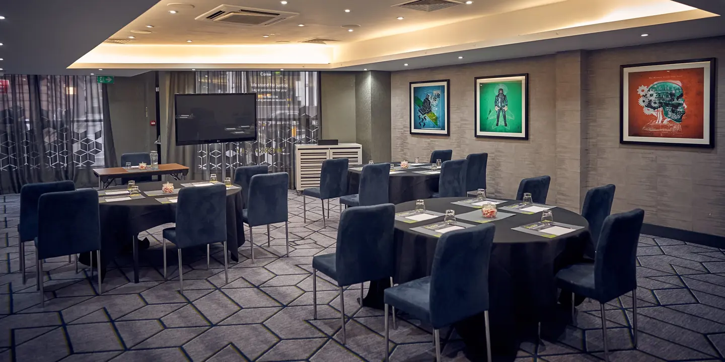 A spacious room adorned with tables, chairs, and wall art.