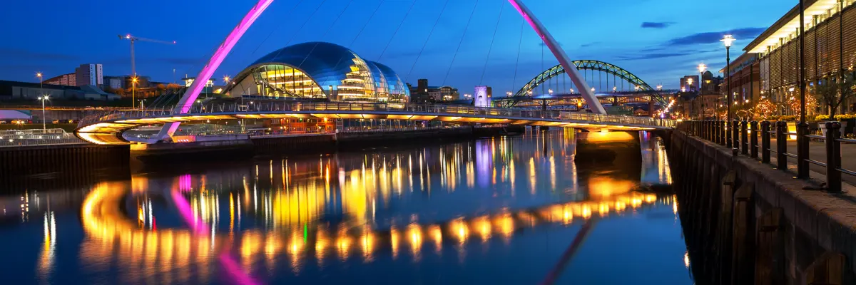 Nighttime view of a bridge spanning over a serene body of water.