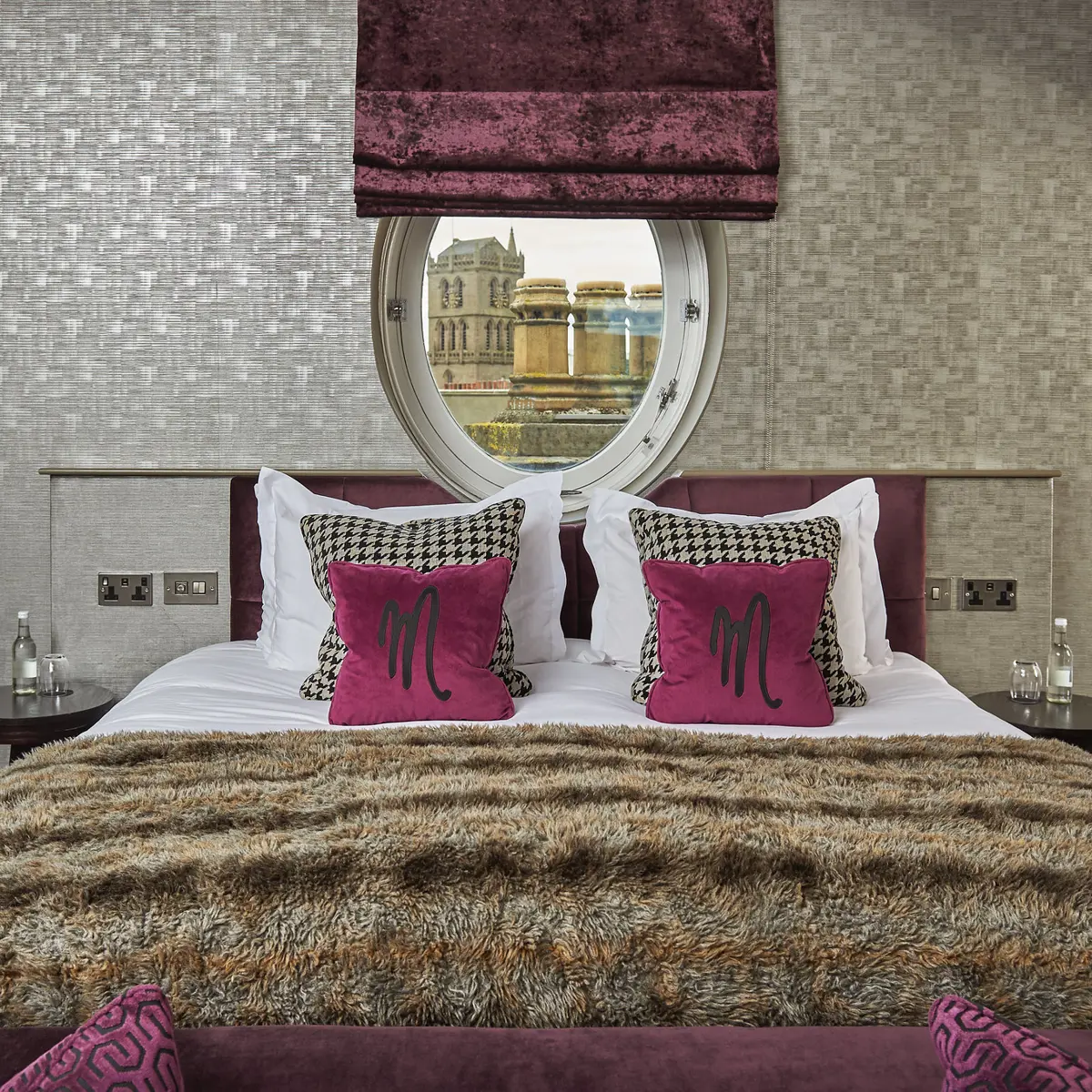 Spacious bedroom featuring a king-sized bed and a circular window.