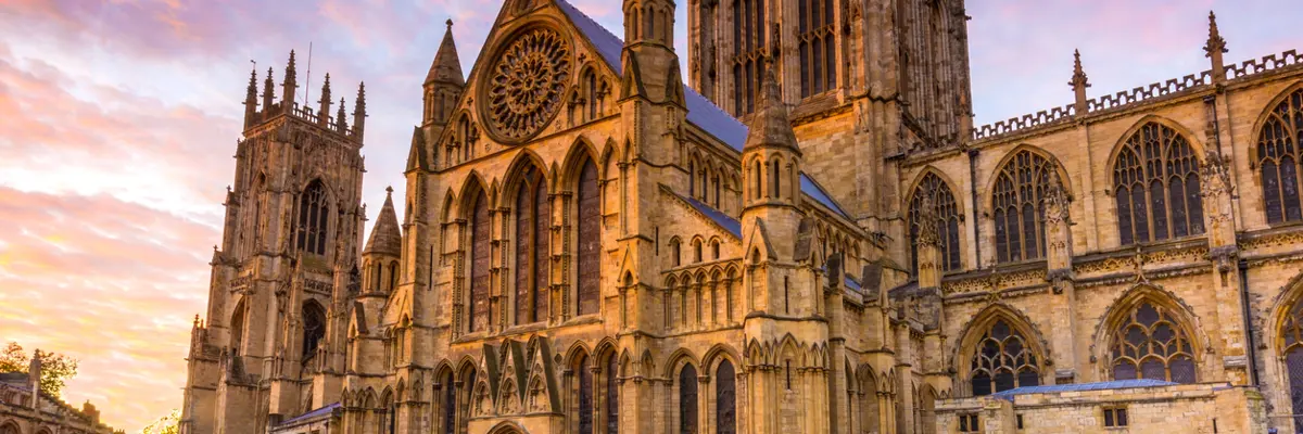 A grand cathedral featuring a prominent clock on its façade.