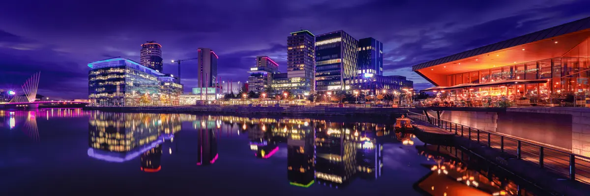 Nighttime view of a city alongside a vast body of water.